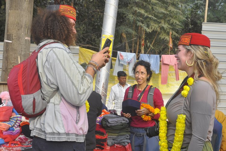 महाकुम्भ मेले में पुण्य की डुबकी लगाने के बाद टोपी खरीदते विदेशी श्रद्वालु